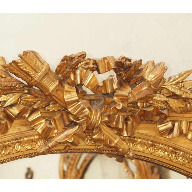 Beautiful hand-carved Napoleon III giltwood mirror. Marriage motifs with torch, laurel leaf and ribbon swags.