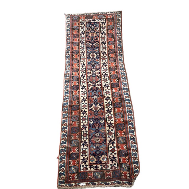 Dating to the early 1900s, this antique Varamin runner rug features a highly decorative composition built around...