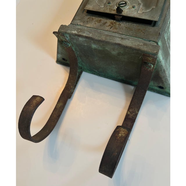 A wonderfully patinated metal mail or letter box with cradle for newspaper and larger pieces of mail. The piece has a slit...