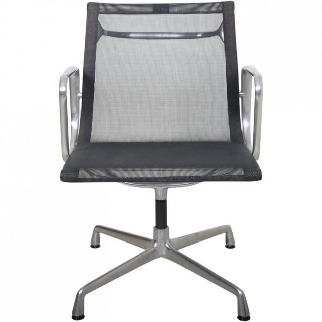 Charles Eames EA-108 office chair with a swivel base, upholstered in black mesh and with a frame and armrests of...