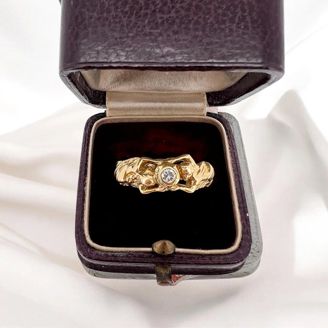 Art Nouveau ring in 18 carat gold (750 thousandths). It is decorated with a central brilliant-cut diamond of approximately...