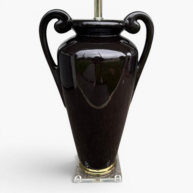 Bring dramatic elegance to your space with this vintage Hollywood Regency ceramic amphora‑urn table lamp, finished in a...