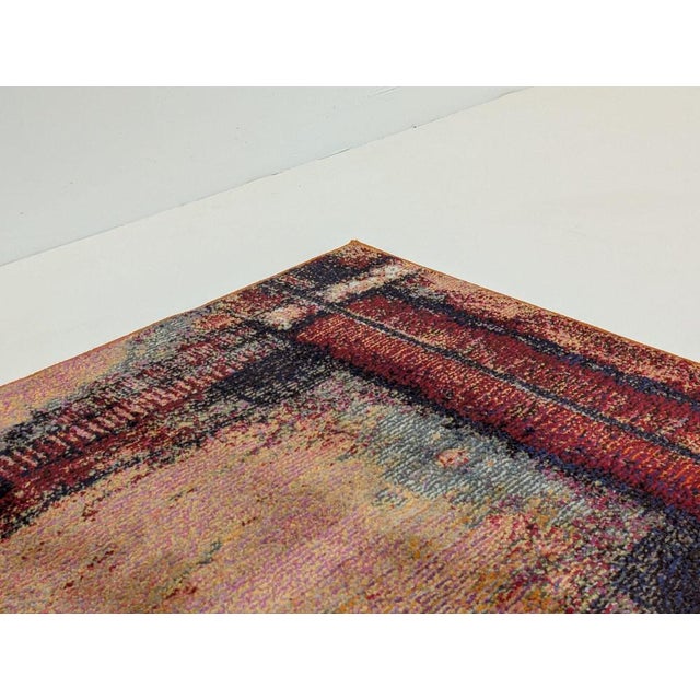 A warm orange field provides the backdrop for a layered, painterly design that blends distressed geometric framing with...