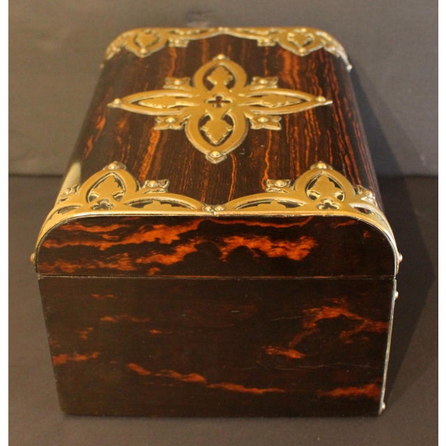 Circa 1880 coromandel brass mounted jewelry box, English. Bramah's patent lock, London. Goth revival strapwork mounts are...