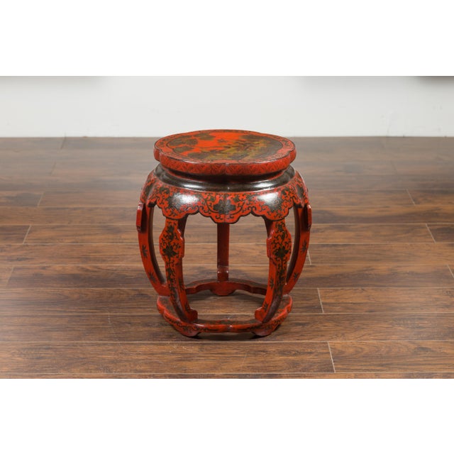 A Chinese Ming Dynasty style red and black lacquered drum stool from the early 20th century, with chinoiserie decor....