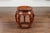A Chinese Ming Dynasty style red and black lacquered drum stool from the early 20th century, with chinoiserie decor....