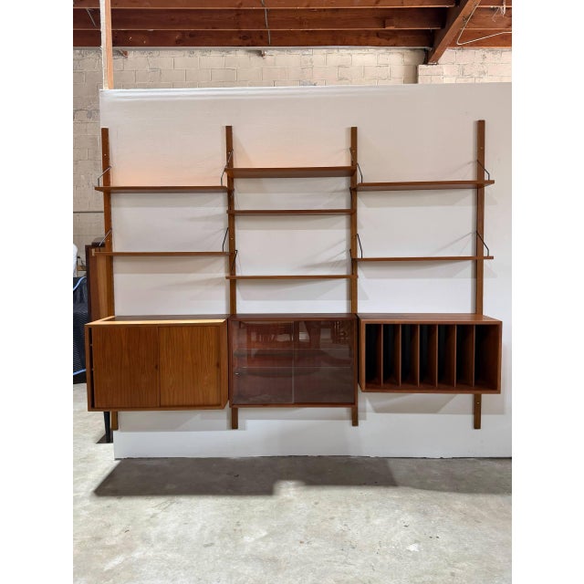 This three-bay modular shelving system offers a versatile wall-mounted storage solution. It features customizable shelves...