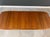 A mid century modern teak dining table with two 20” leaves which fully extend the table to 98.75”. Professionally...