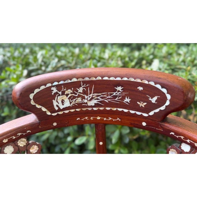 Chinese rosewood corner chair. Beautifully formed, sculptural chair with detailed mother-of-pearl inlay of floral and...