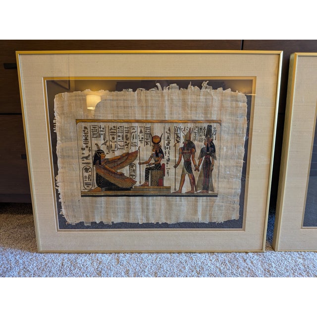 A striking pair of vintage mid-century framed Egyptian papyrus artworks, each measuring 20" x 25". Featuring richly...