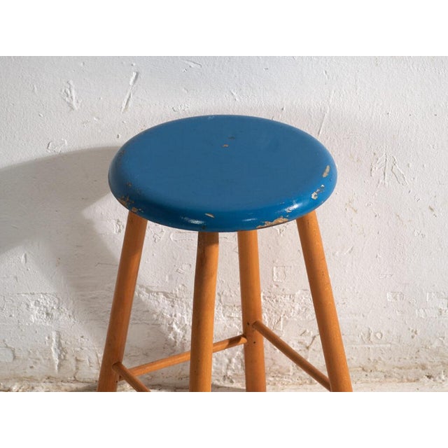This antique wooden stool is a three-legged seat with a round seat and turned splayed legs joined by stretchers. It...