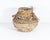 A handwoven artisan basket by Samuel Yao. This basket is woven from various material from palm trees. An artist's card is...
