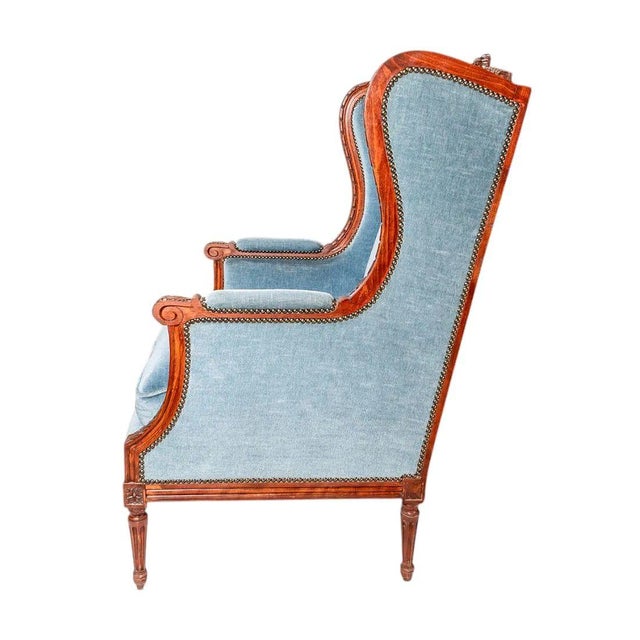 19th Century French Louis XVI-style bergere a oreilles, finely crafted in solid walnut and retaining beautifully carved...