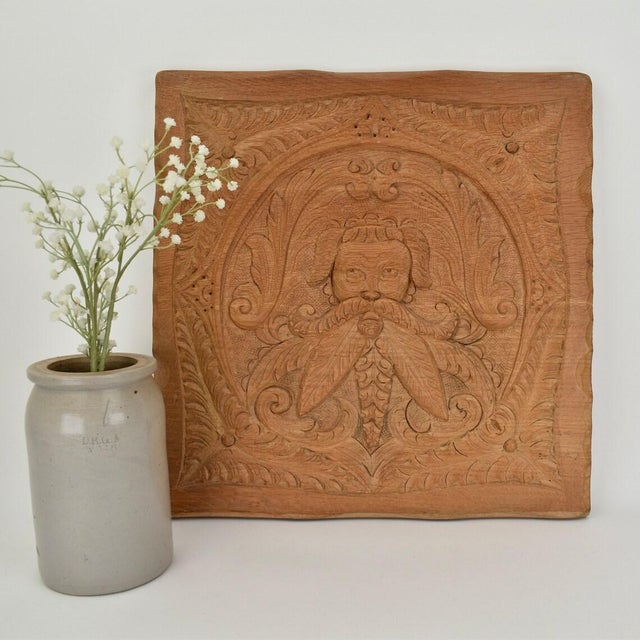 Highly decorative carved wood wall panel. The panel depicts a man with a moustache, and is enriched with patterns all...