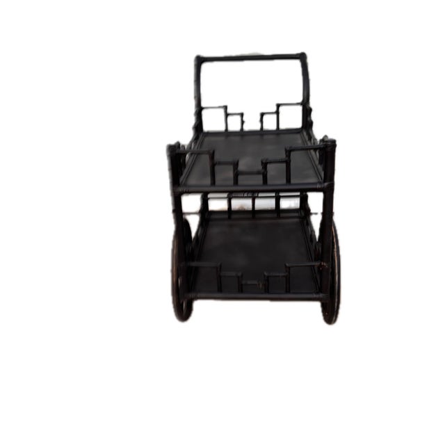 Vintage ebonized rattan bar cart in a chinoiserie style. The cart’s wheels are functional and move with ease. Made of...