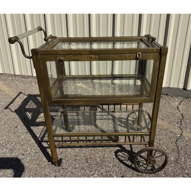 Beautiful antique tea cart with enclosed shelf. Each side has a drop open door. Details are glass handle, wood wheels, and...