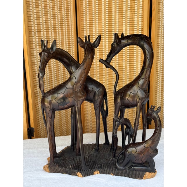 This beautiful and exceptionally solid East African sculpture features an intertwined herd of five giraffes meticulously...