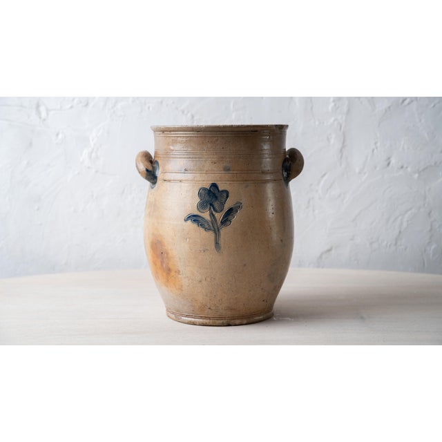 Ovoid salt-glazed stoneware jar with a footed base, tooled collar, and open loop handles, the handle terminals brushed in...