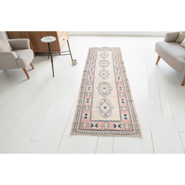 This is a vintage Turkish Oushak rug from the Mid 20th Century. The piece was hand-knotted.