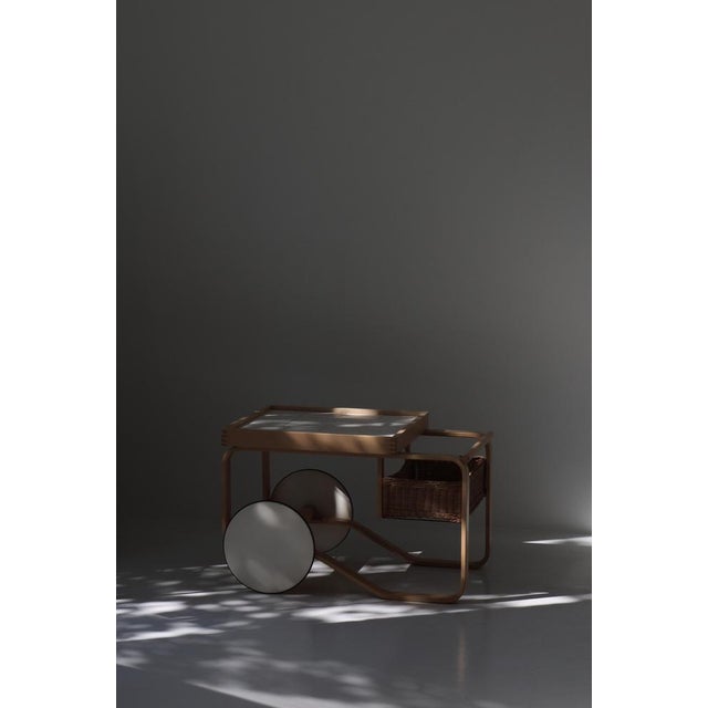 Vintage Alvar Aalto tea trolley model 900 made in the 1960s at Artek, Finland. White ceramic tiles and basket of woven...