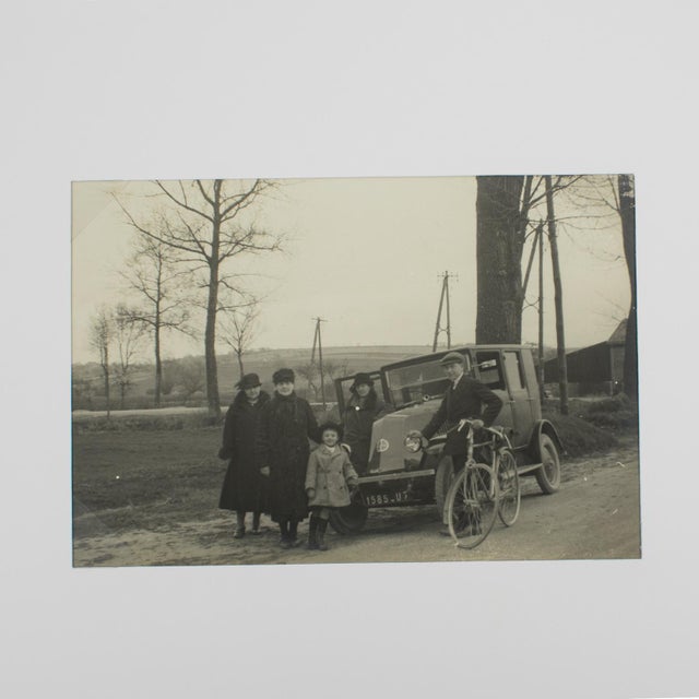 A unique original silver gelatin black and white photograph. A family on the road near Paris, France, circa 1930. The car...