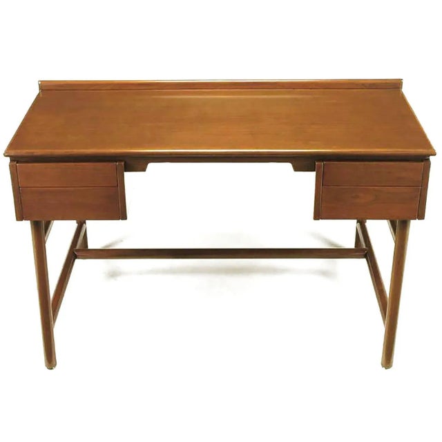 Walnut desk by William Pahlmann with four drawers and front shelf. Unusual base of large intersecting dowels. Restored to...