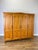 An elegant Vintage French Louis wardrobe in oak, featuring four panelled doors, a gently shaped upper profile, decorative...