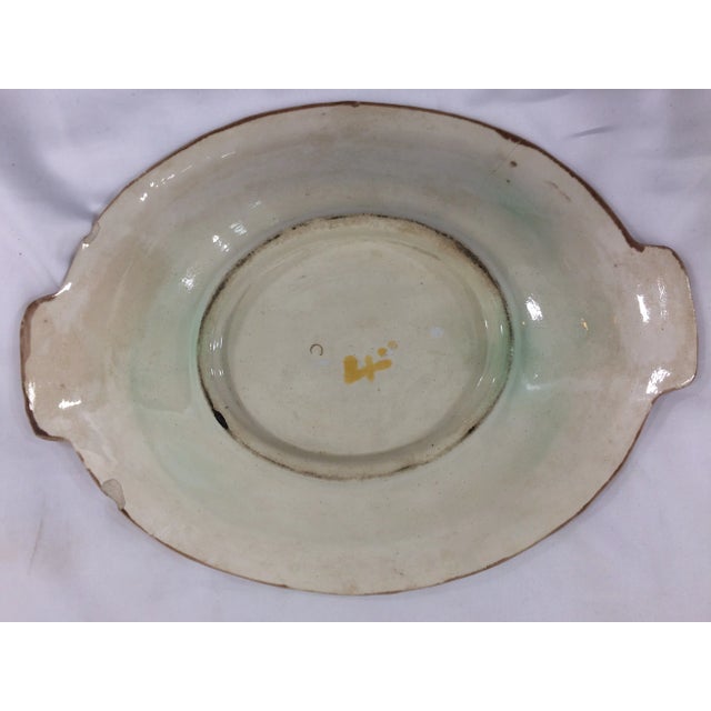 Lovely, oval dish with branch and leaf details and a splash of violet and green glaze. Possibly from Marseilles. Some...