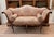A very sculptural Italian walnut settee with a shaped, arched back and graceful outswept arms that end in carved scrolls....