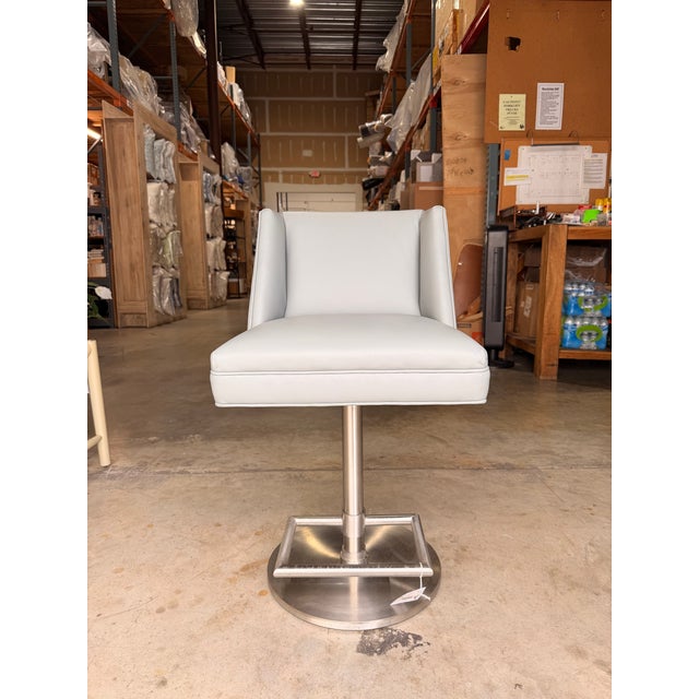 Elevate your space with this contemporary swivel counter chair, upholstered in smooth light gray leather for a clean,...