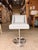 Elevate your space with this contemporary swivel counter chair, upholstered in smooth light gray leather for a clean,...