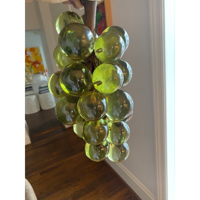 Fabulous bunch of translucent green lucite grapes securely attached to a wood stem. Balls are approximately 2” and appear...