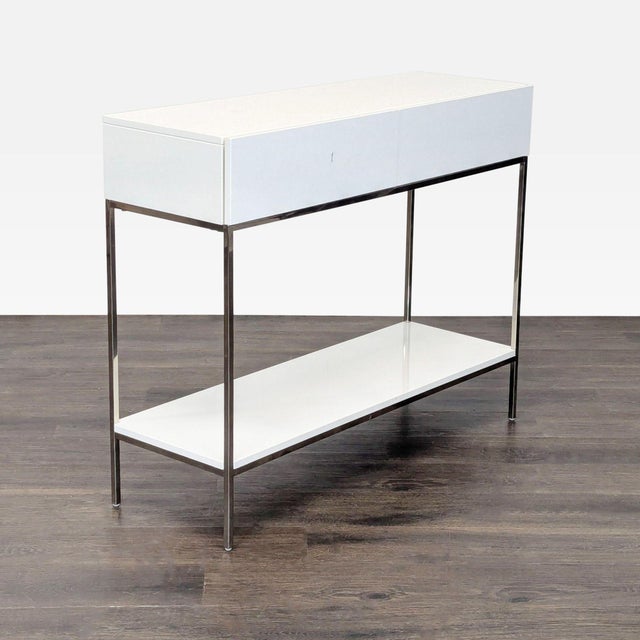White West Elm console table featuring two drawers and a minimalist design. Clean lines, lacquered finish, and a slim...