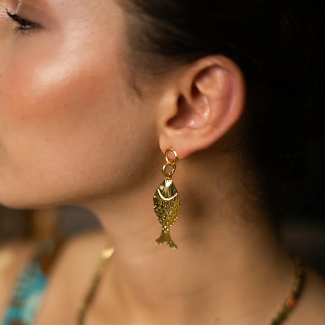 Bring a touch of charm, prosperity, and playful elegance to your style with our Golden Fortune Fish Dangle Earrings....