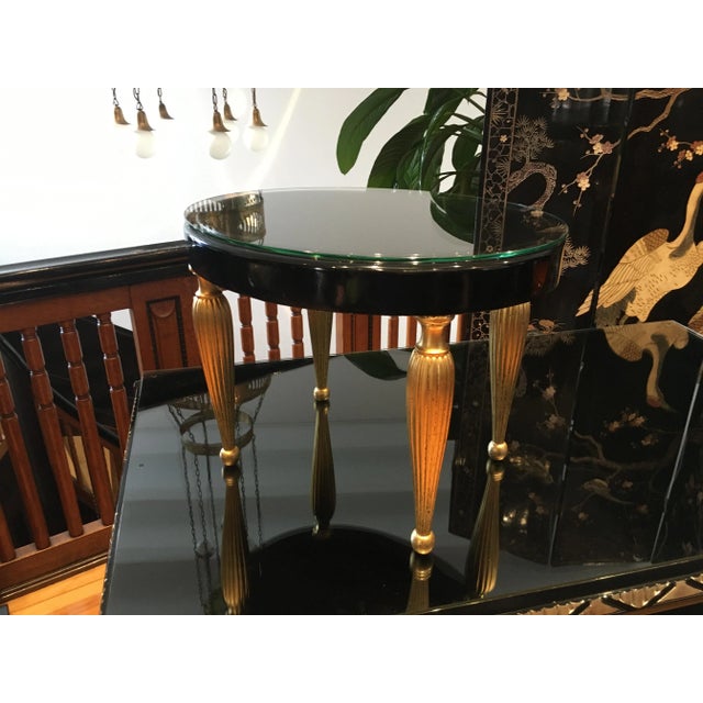 The table is freshly restored, the plate is covered in a high gloss black paint and having a glass plate, the fluted legs...