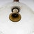 Ceiling lamp with glass shade and wooden shaft. The upper end is surrounded by an irregular bronze relief, signed...