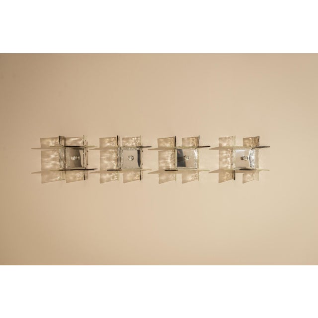 A quiet interplay of glass and light defines this wall composition, where structure becomes atmosphere. Designed by carlo...