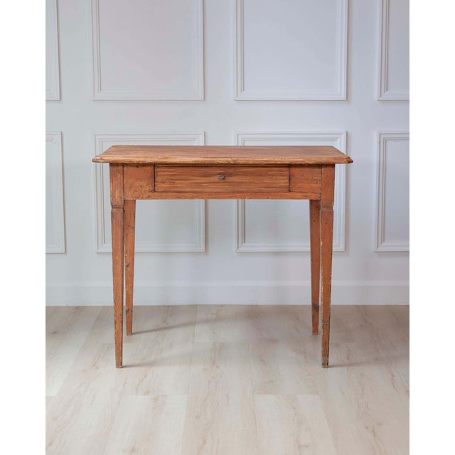 A charming mid-19th-century Swedish side table handcrafted in pine, featuring a clean rectangular top above a single...