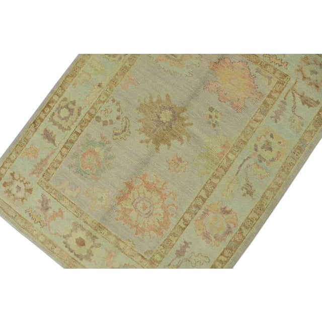 This modern Turkish Oushak rug is a stunning piece of art that has been handwoven using traditional techniques by skilled...