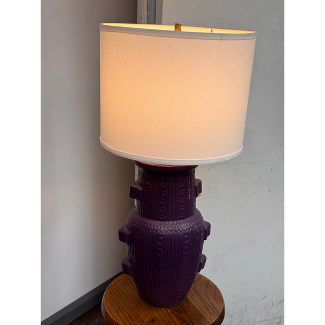 Design Plus Gallery presents a Purple Ceramic Table Lamp. This ceramic lamp has a purple glaze over a raised geometric...