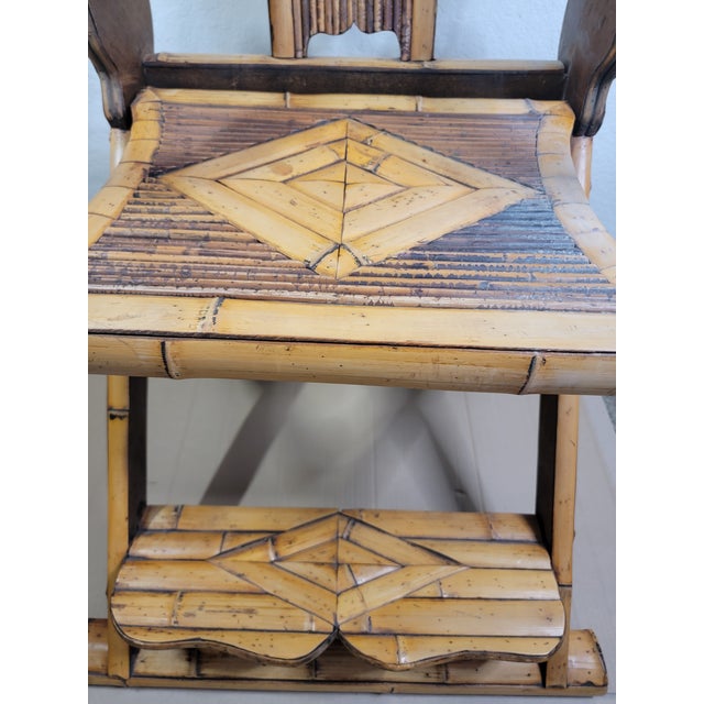 This is an antique bamboo and wood horseshoe-back armchair with intricate craftsmanship and a unique folding footrest. The...