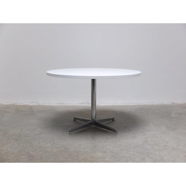 Nice round table produced in Germany around 1975. It has a round top in white formica and a central pedestal base in...
