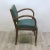 This Art Deco chair was produced in the period 1930 - 1935. It has a wooden frame and is upholstered in dark green Skai...