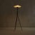 A 1950s Italian floor lamp with a sculptural tripod silhouette. The white-lacquered aluminum shade flares outward in a...