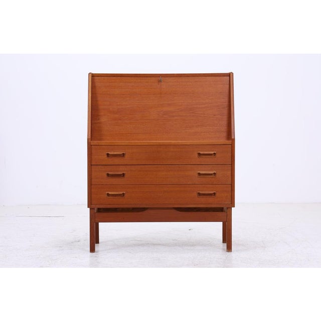 Vintage teak secretary desk by Dyrlund in classic Danish Modern design. Behind the writing flap are practical compartments...