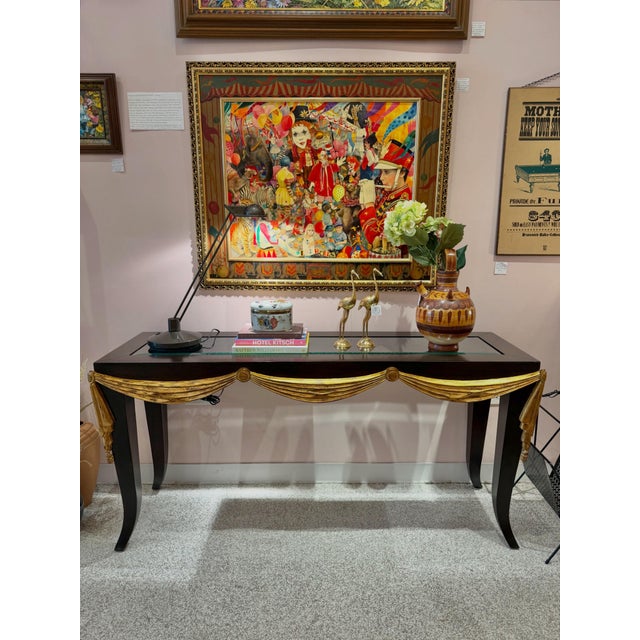 A beautiful French style dark brown wood console table, with carved gold gilt draped valance detail along front and sides....
