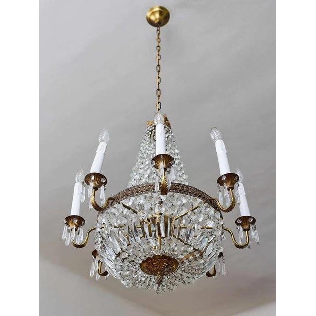 A luxurious crystal chandelier in a classic pear shape with eight elegantly curved arms and five inner lights. This richly...