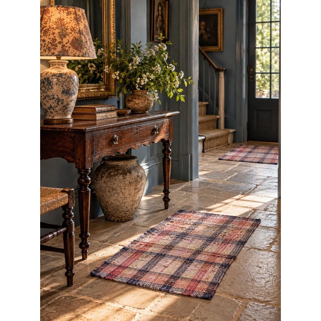 A set of three vintage woven rag rugs featuring a softly faded plaid pattern in dusty rose, cream, tan, and navy. The...