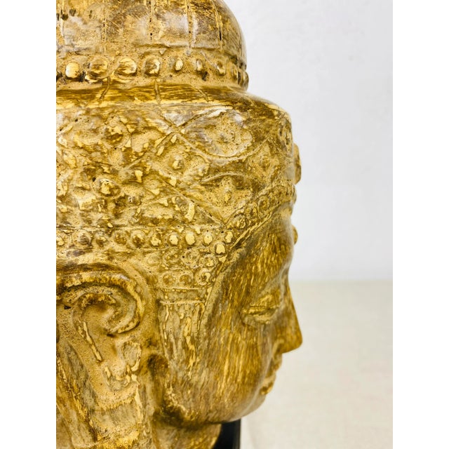 This is a vintage Indonesian figural sculpture of a female. This sculpture stands on a black wooden plinth.