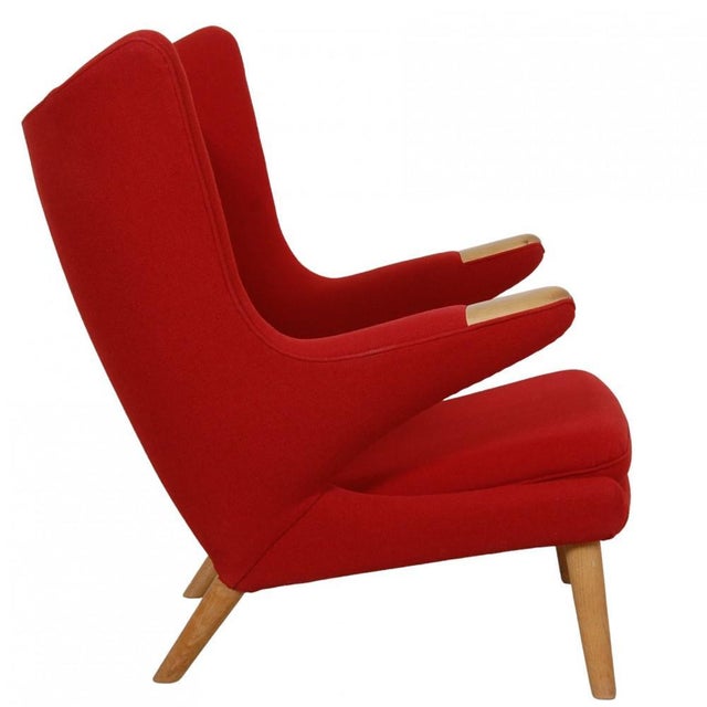 Hans Wegner Papa bear lounge chair upholstered in red Hallingdal fabric, and with legs and nails of oiled oak. The chair...